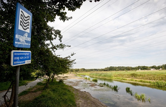 Een bord waarop staat 'Waterwingebied' bij een beek in Deventer