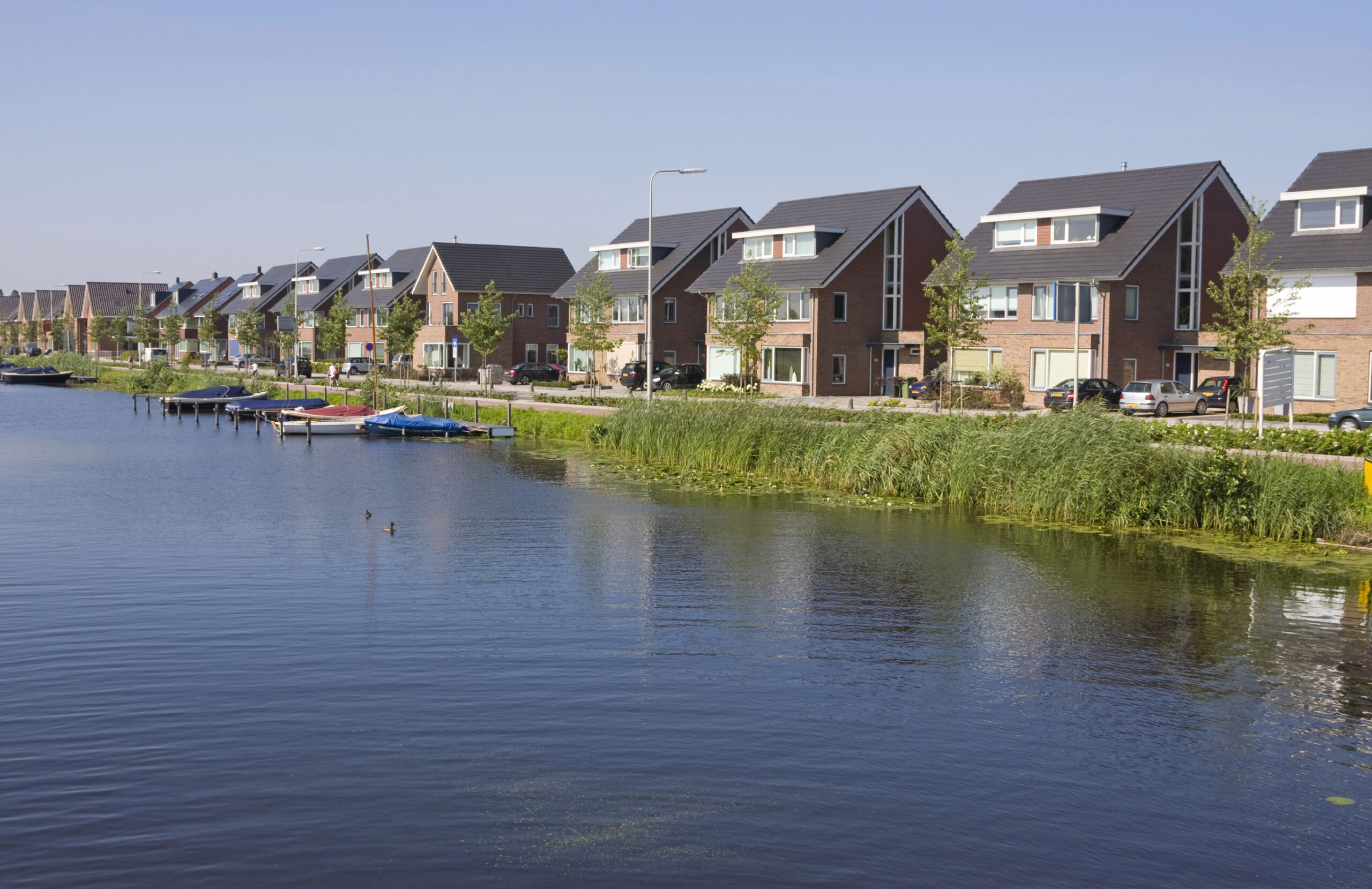 kanaal met erachter huizen aan dijk