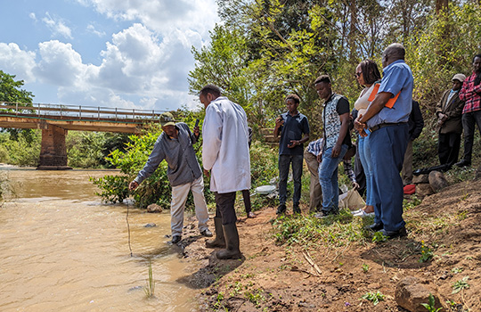 mensen aan over van rivier in Vietnam met erachter een brug