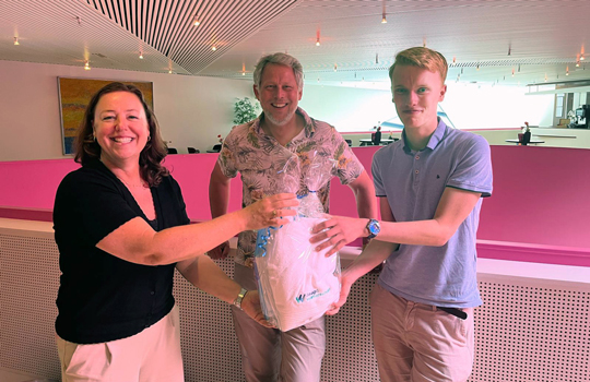 Caroline Matla (educatieadviseur Unie van Waterschappen) en Remco Bosma (dijkgraaf HHNK) bedanken jeugddijkgraaf Darian bij zijn afscheid. Caroline overhandigt een cadeau aan Darian in de foyer van theater Agore in Lelystad.